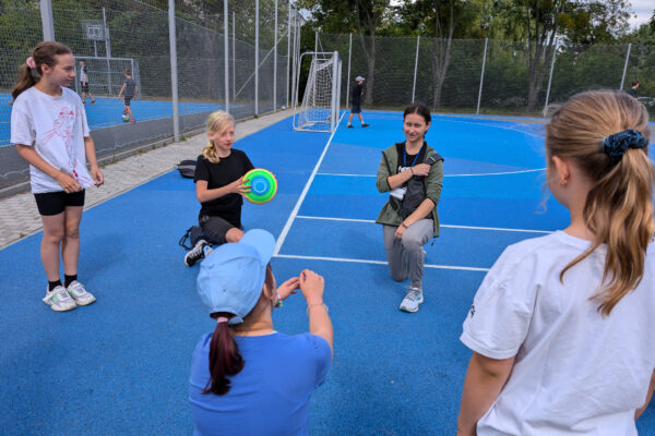 Children and youth play sports on an outdoor court at a camp for Polish and Ukrainian youth (GO Poland)
