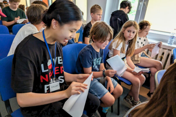 Children practice paper folding at a camp for Polish and Ukrainian youth (GO Poland)