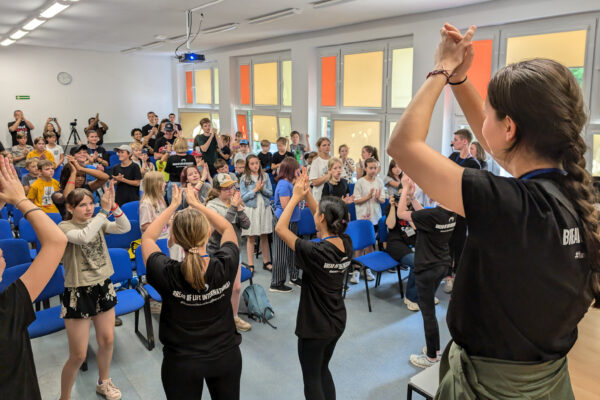 A group of students clap their hands at a camp for Polish and Ukrainian youth (GO Poland)