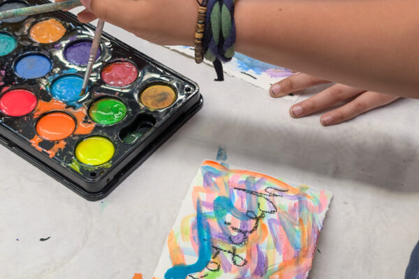 Closeup of kids creating artwork using paint at a camp for Polish and Ukrainian youth (GO Poland)