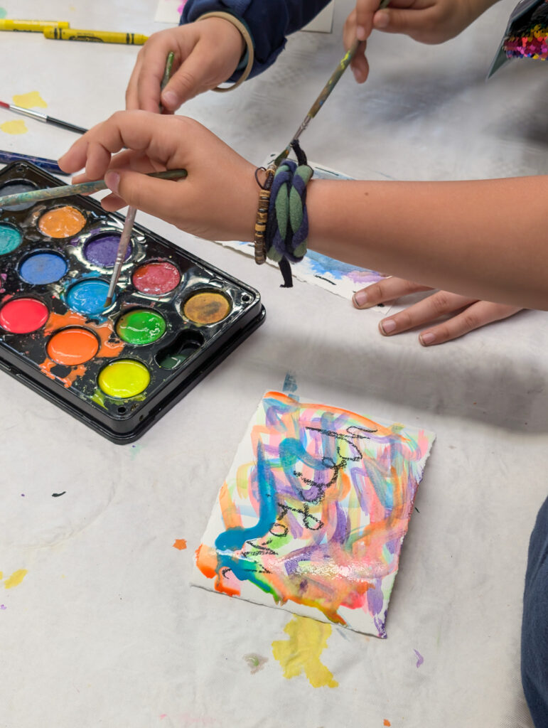 Closeup of kids creating artwork using paint at a camp for Polish and Ukrainian youth (GO Poland)