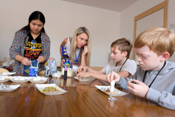 Two boys are helped by a volunteer at a camp for Polish and Ukrainian youth (GO Poland)