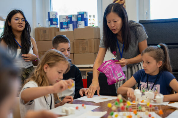 A female volunteer helps students craft at a camp for Polish and Ukrainian youth (GO Poland)