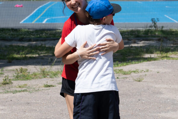 A child hugs a female GO Journey team member in Poland