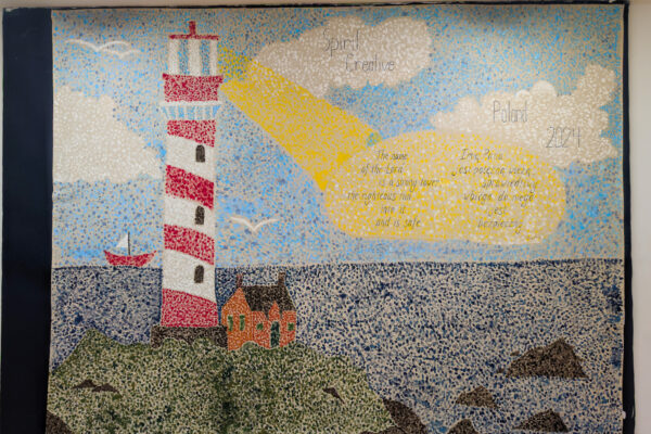 A large wall-sized painting of a lighthouse is displayed at a camp for Polish and Ukrainian youth (GO Poland)