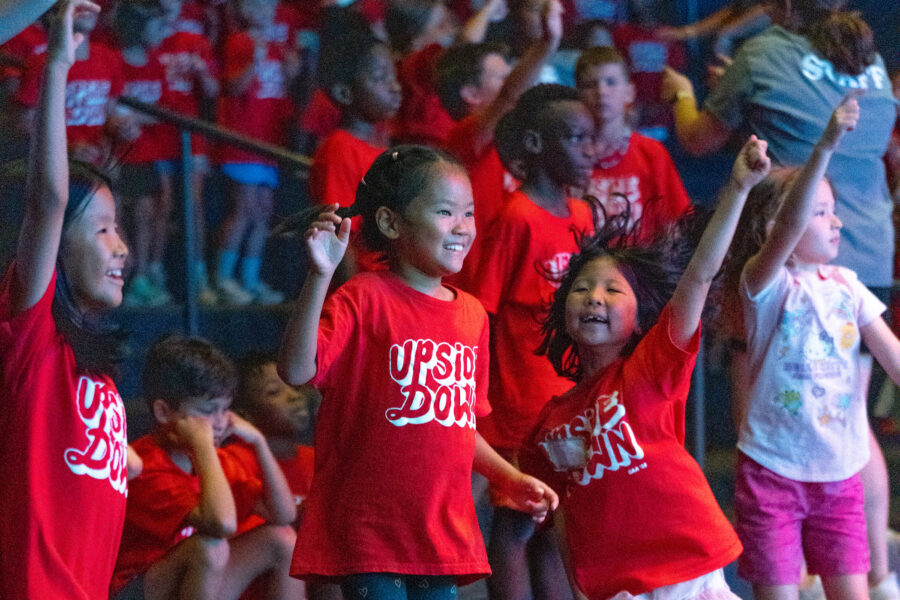 Children engage in singing and worship at Camp All-American