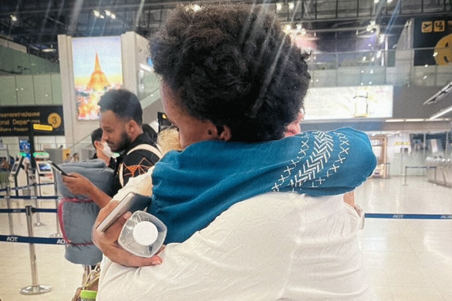 Two women embrace at an airport