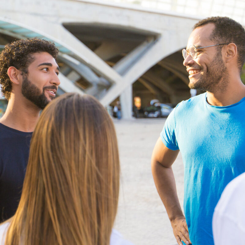 A multi-ethnic group of friends standing outside and talking