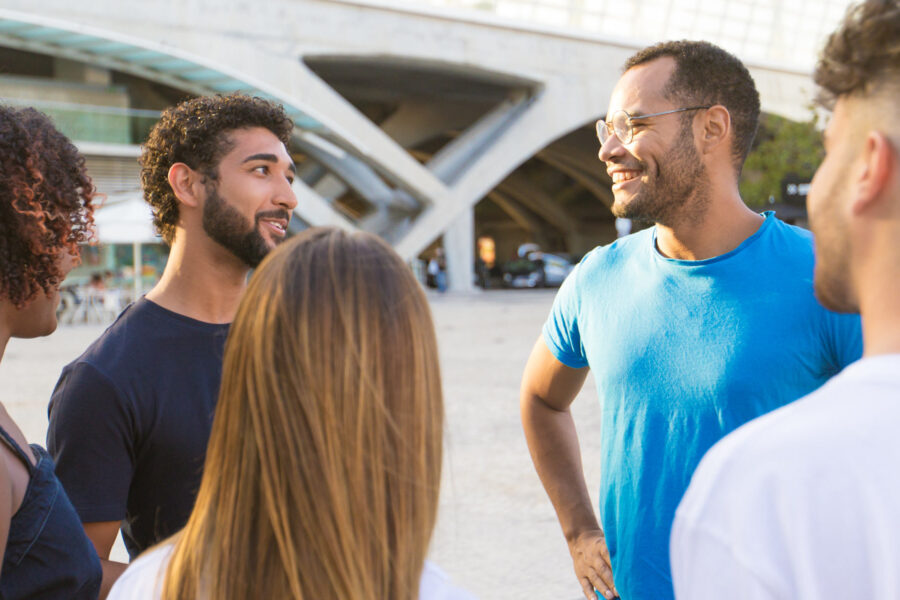 A multi-ethnic group of friends standing outside and talking