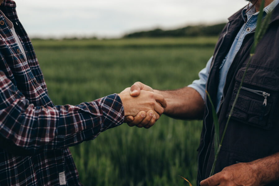 Two men greet each other with a handshake