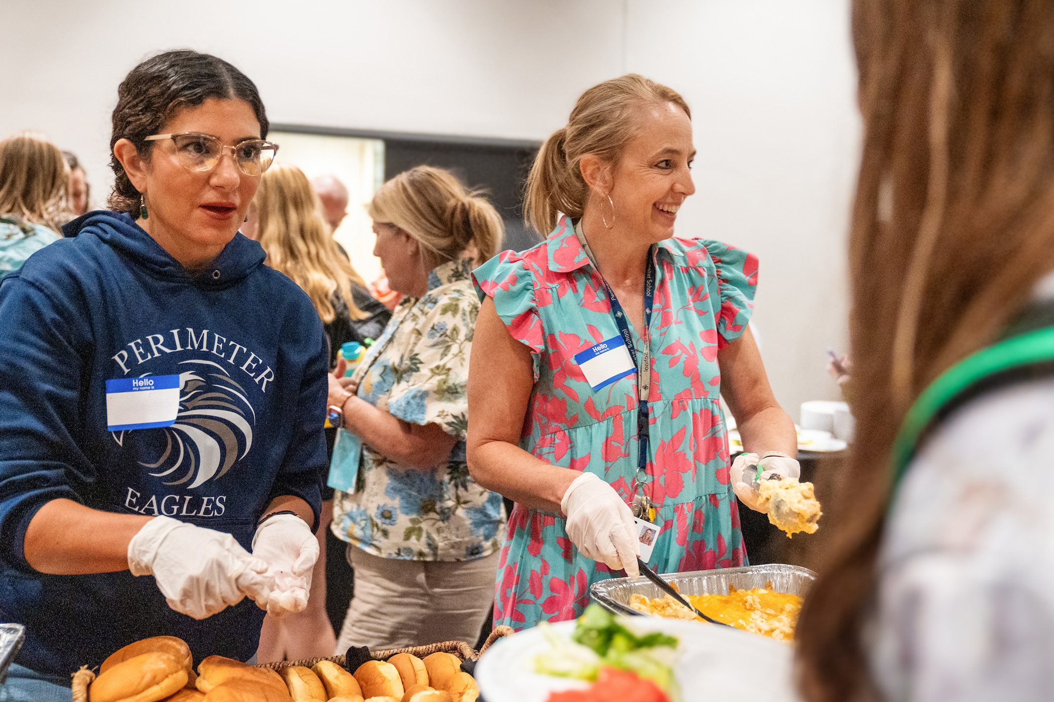 Adult volunteers serve food at the Rush summer conference